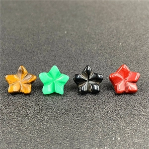 Dettaglio macro di quattro ciondoli in pietra naturale a forma di stella colorati
