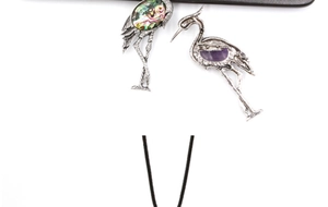 Detailed view of red-crowned crane pins with inlaid abalone shell and purple gemstones