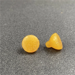 Dettaglio macro di ciondoli a baccello di loto gialli in pietra di agata lucida
