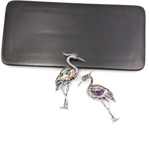 Front and back view of crane brooch with abalone shell inlay and purple gemstone