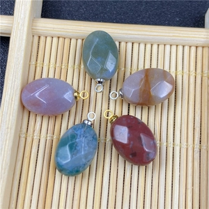 Macro view of five faceted oval agate pendants with metal loops in a bamboo tray