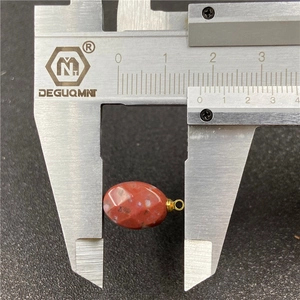 Calibrated measurement of an oval red agate faceted pendant bead with a gold jump ring