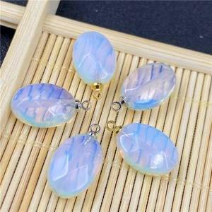 Macro detail of blue oval opal pendants with radial texture and metal bail hooks