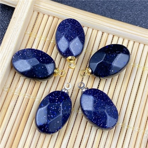 Macro shot of blue sandstone oval faceted charms with gold and silver metal bails
