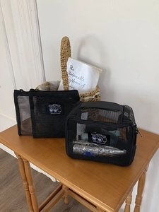 Macro shot of breathable black mesh travel pouch with zipper and cute bear cartoon patch