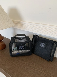 Detail of mesh toiletry bag set showing breathable material and cartoon bear label