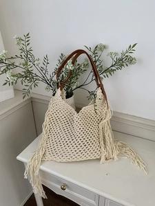 Close-up of bohemian woven tote bag with cream cotton crochet and tassel details