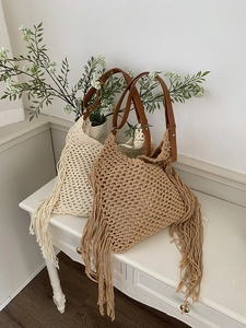 Detail of crochet hollow tote bags with ethnic fringe and adjustable leather straps
