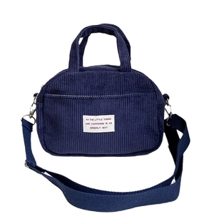 Navy blue corduroy mini bowling bag with dual handles and fabric shoulder strap