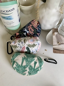 Detailed embroidery storage bags with floral patterns and metal carabiner clips