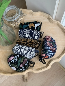Close-up of heavy embroidery flower patterns on small zipper pouch storage bags