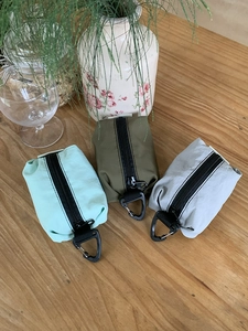 Trois pochettes en nylon menthe, olive et gris avec zips et boucles en anneau en D