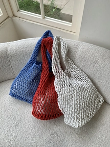 Three handmade woven tote bags in blue, red, and white with drawstring inner liners
