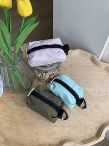 Trois mini pochettes en nylon rose, vert et menthe avec mousquetons de transport