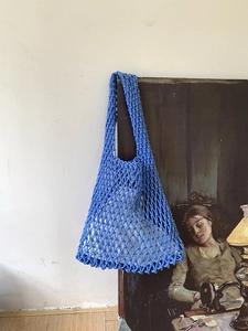 Blue handmade crochet tote bag with cotton lining in a vintage aesthetic setting