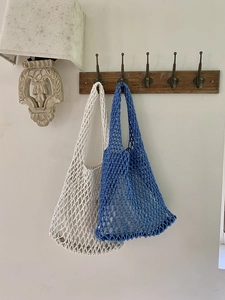 Detail of white and indigo hand-woven cotton mesh tote bags showing large hole structure
