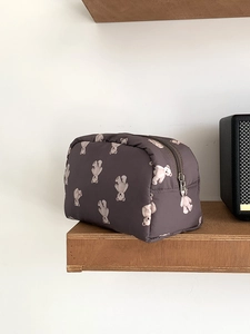 Large capacity makeup bag with cute bear pattern in dark taupe on a wooden shelf