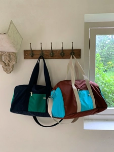Detail of color-block nylon tote bags hanging in a cozy indoor lifestyle setting