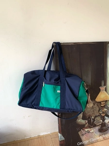 Two-tone nylon tote bag in navy and green with shoulder straps for travel and yoga