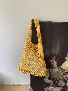 Detail of yellow handwoven mesh tote bag with thick cotton rope and inner fabric lining