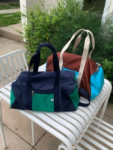 Detail of multi-color nylon tote bags with durable zippers and adjustable straps for travel