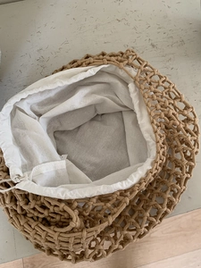 Detail of khaki woven mesh tote bag featuring a white drawstring inner pouch liner