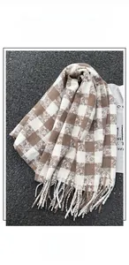 Detail of caramel and white plaid scarf featuring classic fringe and soft cashmere-like texture