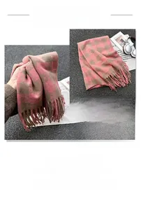 Macro detail of pink and brown plaid knit scarf with soft tassels and thick texture