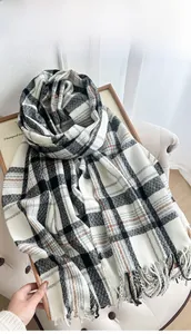 Close-up of thick plaid winter scarf featuring heavy texture and long fringe tassels