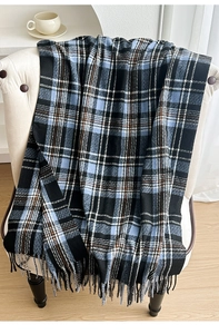 Close-up of classic blue and black checkered winter scarf with soft fringe details