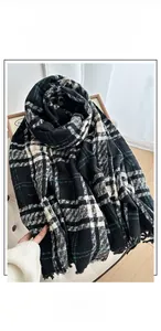 Dettaglio della sciarpa a quadri con nappe in nero e verde con morbida consistenza in cashmere