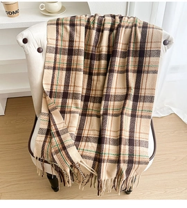 Close-up of classic beige and brown plaid scarf with soft texture and long fringe details