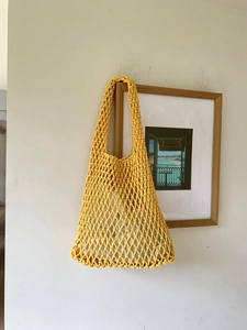 Handmade yellow woven tote bag with hollow mesh pattern and comfortable shoulder strap