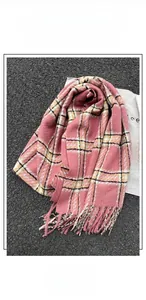 Detailed texture of pink and yellow cashmere-like scarf with soft fringe tassels