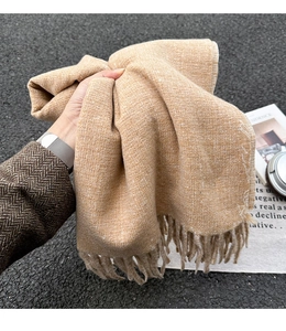 Detailaufnahme von Strickschal in Haferfarbe mit weicher Textur und Fransen