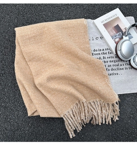 Detailansicht eines kamelfarbenen dicken Fransenschals mit Wolltextur auf Lifestyle-Grund