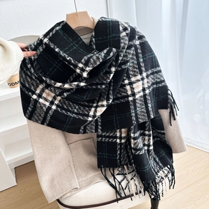 Sciarpa classica a quadri neri e verdi con frange su un elegante cappotto invernale beige