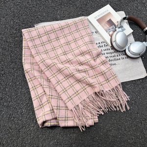Pink and yellow plaid scarf with fringe on a canvas bag with lifestyle accessories