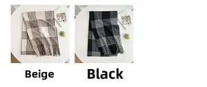 Classic checkered scarves in beige and black with fringed edges on a minimalist desk