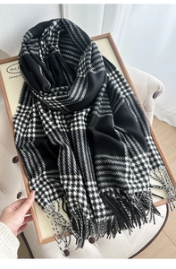 Detail of classic black and white checkered scarf with soft fringe and knit texture