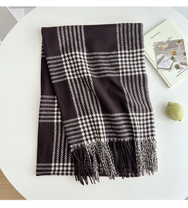Detailed close-up of dark coffee and white plaid scarf with decorative fringe tassels