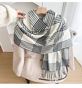 Close-up of black and white checkered scarf with tassel detail on wool coat
