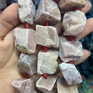 Vue rapprochée des perles brutes en pierre de soleil naturelle montrant la texture minérale