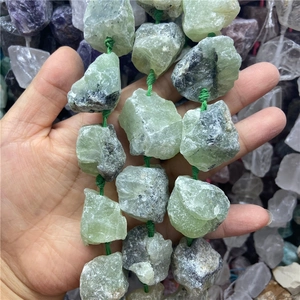Gros plan de perles de pierre de préhnite brute naturelle avec fil vert pour bijoux