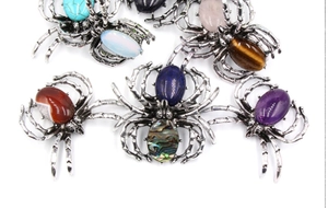 Détail macro de broches d'araignée en argent rétro avec diverses incrustations de pierres