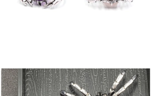 Détail macro d'une broche araignée gothique avec pierres violettes et roses sur métal