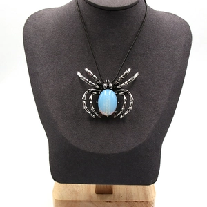 Collier avec pendentif araignée vintage serti d'une pierre bleue sur présentoir en velours