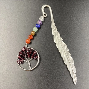 Close-up of silver feather bookmark with seven chakra beads and tree of life charm