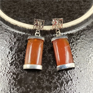 Detail von Vintage Silberohrringen mit rotem Achat und Fu-Zeichen auf schwarzer Basis