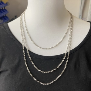 Three-layer silver circle chain necklace in tiered design on a jewelry display stand